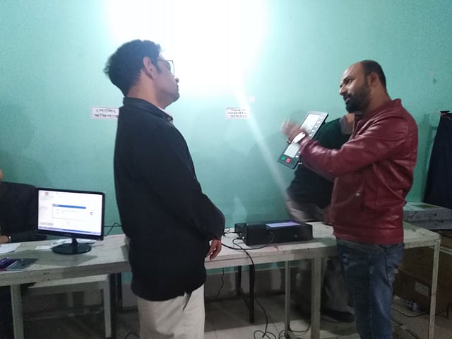 ডেমো যন্ত্র দিয়ে একজন ভোটারকে ইভিএমে ভোট দেওয়া বুঝিয়ে দিচ্ছেন নির্বাচনী দায়িত্বে নিয়োজিত এক ব্যক্তি। ছবি: প্রথম আলো