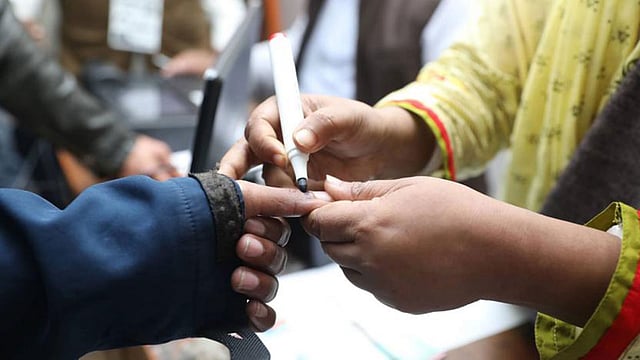 এক ভোটারের আঙুলে অমোচনীয় কালি লাগানো হচ্ছে। বেগম বদরুন্নেসা সরকারি মহিলা কলেজ কেন্দ্র, ঢাকা, ১ ফেব্রুয়ারি। ছবি: আবদুস সালাম