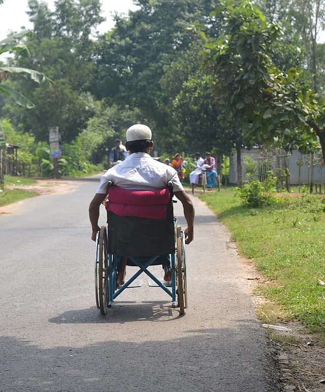 পিচঢালা পথ ধরে হুইলচেয়ারের নয় জীবনের চাকা ঘোরাচ্ছেন নূর নবী। ছবি: লেখক