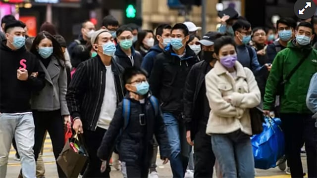 চীনের উহান শহরে পথচারীরা মাস্ক পরে চলাচল করছে। ছবি: এএফপি
