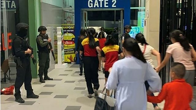 নিরাপত্তা বাহিনীর সদস্যরা শপিং সেন্টার থেকে লোকজনকে বের করে নিয়ে যাচ্ছে। ছবি: এএফপি