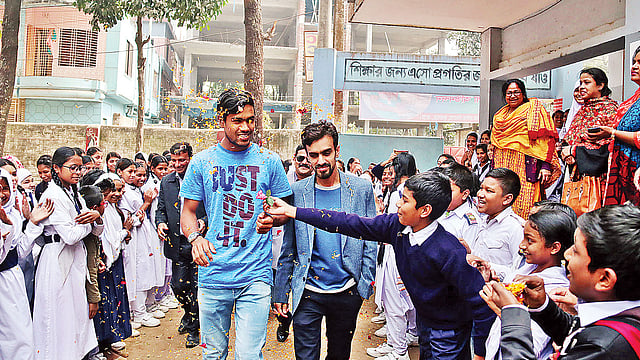 ক্রিকেটার আকবর আলীকে ফুল দিয়ে স্বাগত জানায় শিক্ষার্থীরা। গতকাল রংপুর নগরের জুম্মাপাড়ার বেগম রোকেয়া বালিকা উচ্চবিদ্যালয়ে।  ছবি: প্রথম আলো