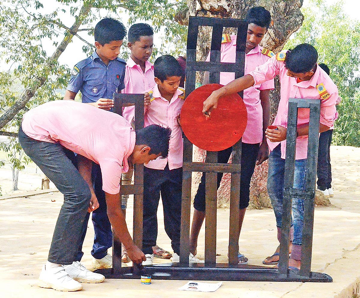 দীঘিনালার কবাখালী প্রাথমিক বিদ্যালয়ে তৈরি অস্থায়ী কাঠের শহীদ মিনারে রং করছে শিক্ষার্থীরা। গত মঙ্গলবার দুপুরে বিদ্যালয় প্রাঙ্গণে।  প্রথম আলো