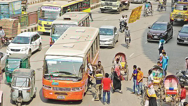নতুন সড়ক আইন হওয়ার পরও এখনো শৃঙ্খলা ফিরছে না। সড়কের মধ্যেই যাত্রী ওঠানামা করাচ্ছেন বাসচালকেরা। গতকাল দুপুরে রাজধানীর মিরপুর ১ এলাকায়।  ছবি: প্রথম আলো
