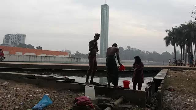 স্বাধীনতা স্তম্ভ জলাধারে আজ সোমবার (১৫ ডিসেম্বর, ২০১৪) ছিন্নমূল মানুষেরা গোসল করছেন। ছবি: মনিরুল আলম