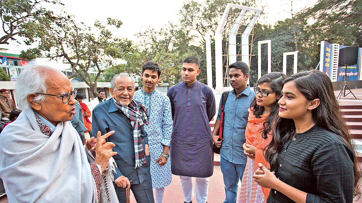 ভাষাসংগ্রামী আহমদ রফিক (বাঁয়ে) ও সাঈদ হায়দার (বাঁ থেকে দ্বিতীয়) ভাষাসংগ্রামের গল্প শোনাচ্ছেন এই প্রজন্মের পাঁচ তরুণ ও তরুণীকে। ১২ ফেব্রুয়ারি বিকেলে কেন্দ্রীয় শহীদ মিনারের সামনে।  ছবি: হাসান রাজা