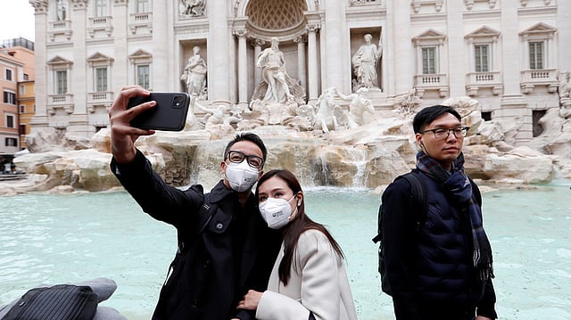 রোমে ভ্রমণের সময় পর্যটকেরাও মাস্ক ব্যবহার করছেন। ছবি: রয়টার্স