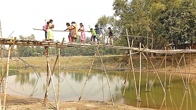 সাঁকোর ওপর দিয়ে ঝুঁকি নিয়ে পার হচ্ছে শিশুরা। সম্প্রতি রংপুরের পীরগাছা উপজেলার প্রতিপাল গ্রামে বুড়াইল নদের ওপর।  ছবি: প্রথম আলো