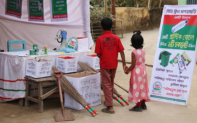 বিডি ক্লিন খাগড়াছড়ির স্টলে পরিচ্ছন্নতার বিভিন্ন উপকরণ দেখছে দুই শিশু