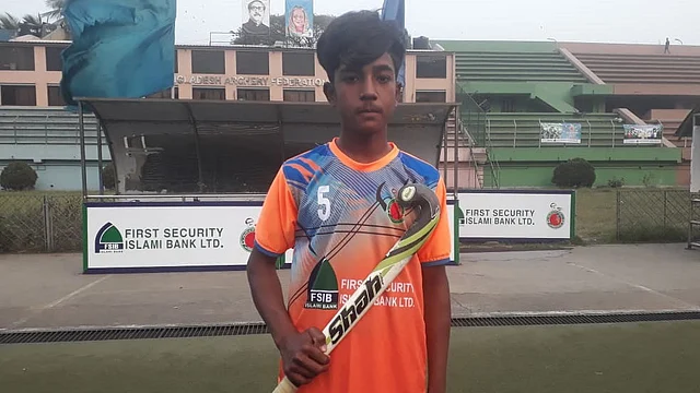 হকিস্টিক হাতে মোটর মেকানিক রহমান হোসেন। কাল মওলানা ভাসানি স্টেডিয়ামে। ছবি: প্রথম আলো।