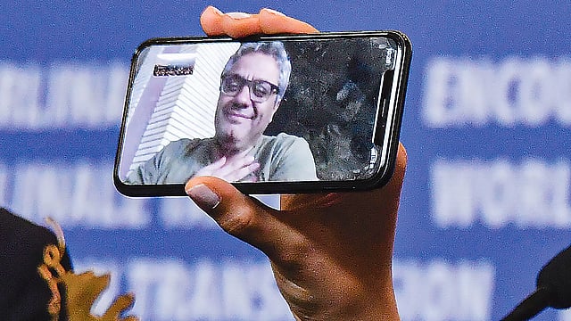 মোহাম্মদ রসৌলফ ইরান সরকারের নিষেধাজ্ঞার কারণে আসতে পারেননি উৎসবে। মোবাইল ফোনে ভিডিও কলের মাধ্যমে সংবাদ সম্মেলনে অংশ নেন তিনি।  ছবি: এএফপি