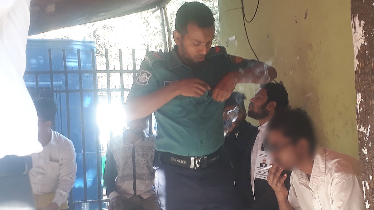 সিগারেট চাইলে পুলিশ সদস্যই তা কিনে দেন কিশোর এক আসামিকে। ছবি: আসাদুজ্জামান
