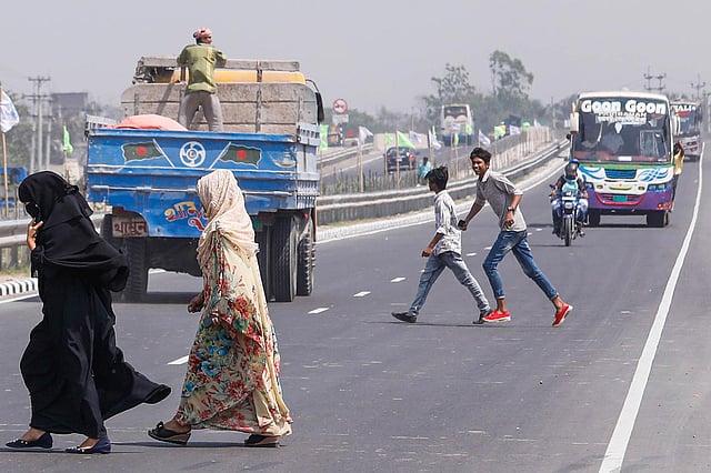 এক্সপ্রেসওয়ের মধ্য দিয়ে সড়ক পার হচ্ছেন পথচারীরা। ছবি: দীপু মালাকার