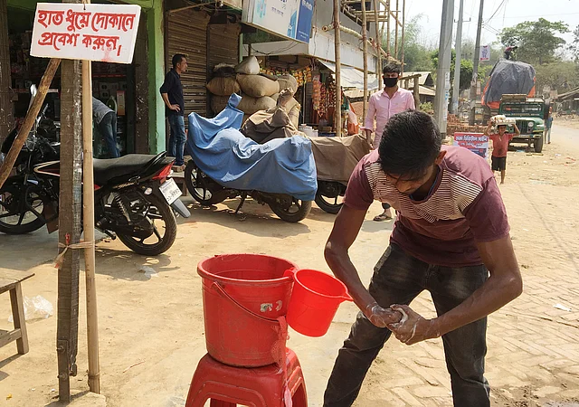 দোকানের সামনে টুলের ওপর বালতিতে পানি ও সাবান রাখা হয়েছে। পাশে টাঙানো হয়েছে ‘হাত ধুয়ে দোকানে প্রবেশ করুন’ নির্দেশনা। করোনা সচেতনতায় এই উদ্যোগ। দীঘিনালা, খাগড়াছড়ি, ২৩ মার্চ। ছবি: পলাশ বড়ুয়া