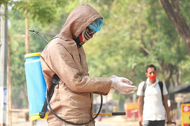 করোনাভাইরাসের সংক্রমণ ঠেকাতে জীবাণুনাশক স্প্রে করার প্রস্তুতি নিচ্ছেন এক ব্যক্তি। জিরোমাইল, খাগড়াছড়ি, ২৫ মার্চ। ছবি: নীরব চৌধুরী