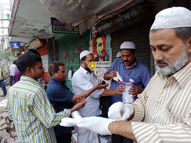 হকার ও এজেন্টদের কাছে মাস্ক ও গ্লাভস সরবরাহ করা হচ্ছে। বুধবার রাজধানীর মতিঝিলে। ছবি: প্রথম আলো