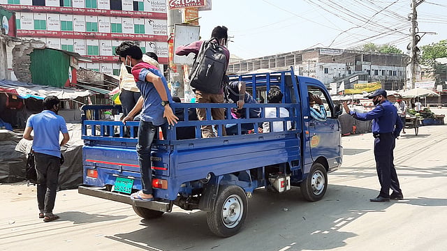 শুক্রবার সকালে ঢাকা-আরিচা মহাসড়কে পিকআপ ভ্যান ও ট্রাকে যাত্রীদের গ্রামে যেতে দেখা গেছে। ছবি: প্রথম আলো