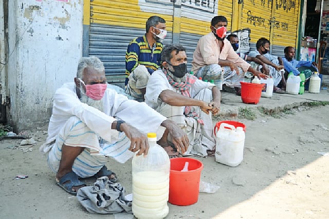 করোনাভাইরাসের প্রভাবে বিপাকে পড়েছেন দুগ্ধ খামারিরা। হোটেল ও চায়ের দোকান বন্ধ। দুধ কিনছে না সাধারণ মানুষও। ফলে পানির দামেও দুধ বিক্রি করতে পারছেন না খামারিরা। গতকাল পাবনার টেবুনিয়া হাটে।  ছবি: হাসান মাহমুদ