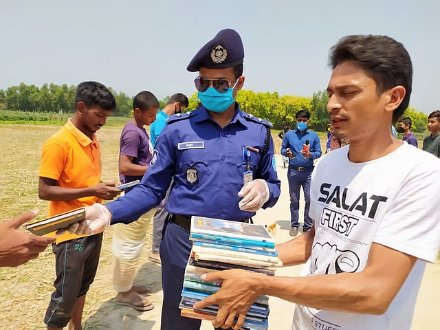 কিশোরদের বই উপহার দিচ্ছেন সহকারী পুলিশ সুপার মো. আল মামুন। চকপাড়া গ্রাম, শ্রীপুর উপজেলা, গাজীপুর, ১ এপ্রিল। ছবি: প্রথম আলো
