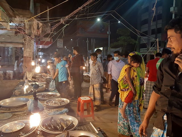 রাতে মাছ ও সবজি কিনতে বাজারে ক্রেতার ভিড়। মদিনামার্কেট, সিলেট নগর, ১ এপ্রিল। ছবি: প্রথম আলো।