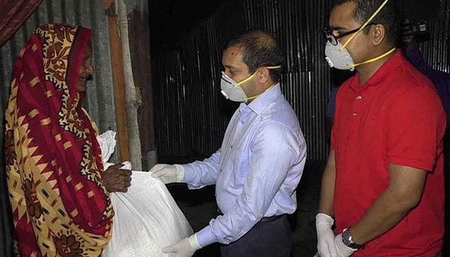 ভিক্ষুক সাবিয়ার হাতে গতকাল শুক্রবার রাতে খাদ্যসামগ্রী ‍তুলে দেন নওগাঁর জেলা প্রশাসক হারুন-অর-রশীদ। ছবি: সংগৃহীত