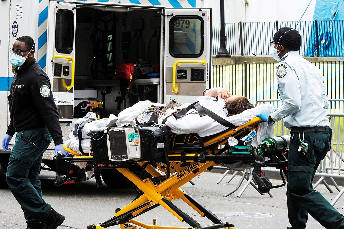 স্বাস্থ্যকর্মীরা একজন অসুস্থ ব্যক্তিকে নিয়ে যাচ্ছেন হাসপাতালে। ছবিটি ৫ এপ্রিল নিউইয়র্ক নগরের এলমহার্স্ট হাসপাতালের সামনে থেকে তোলা। -রয়টার্স