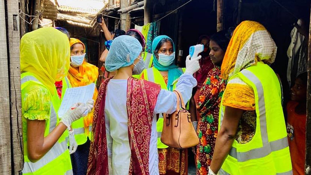স্বেচ্ছাসেবক নাদিয়া আফরিন অন্য নারীদের সঙ্গে বস্তির মানুষের সুরক্ষায় কাজ করছেন। ছবি: সংগৃহীত