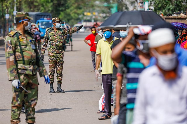 টিসিবির ট্রাক সেলের লাইনে নাগরিকদের মধ্যে নির্দিষ্ট দূরত্ব বজায় রাখতে সেনাসদস্যদের তৎপরতা। মতিঝিল, ঢাকা, ১২ এপ্রিল। ছবি: দীপু মালাকার