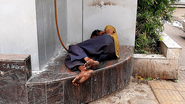 একটি ভবনের সামনের অংশে ঘুমিয়ে আছেন একজন গৃহহীন ব্যক্তি। করোনাভাইরাস বিস্তারের সময় তাঁদের সতর্ক থাকার সুযোগ কম। কারওয়ান বাজার, ঢাকা ১২ এপ্রিল। ছবি: মানসুরা হোসাইন