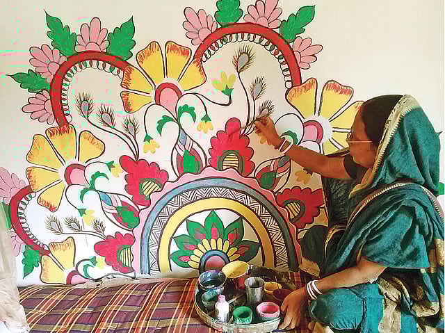 পুরোনো আলপনাতেই পয়লা বৈশাখ উপলক্ষে রঙের প্রলেপ দিচ্ছেন দেখন বালা। গতকাল চাঁপাইনবাবগঞ্জের নাচোল উপজেলার নেজামপুর ইউনিয়নের টিকইল গ্রামে।  ছবি: প্রথম আলো