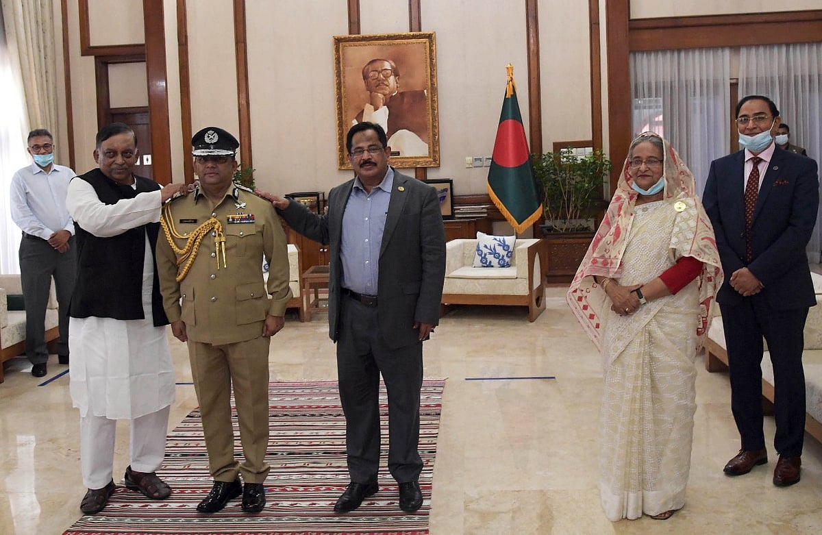 প্রধানমন্ত্রী শেখ হাসিনার উপস্থিতিতে বেনজীর আহমেদকে পুলিশ মহাপরিদর্শকের র্যাঙ্ক ব্যাজ পরিয়ে দেন স্বরাষ্ট্রমন্ত্রী আসাদুজ্জামান খান। ছবি: পুলিশ সদর দপ্তর
