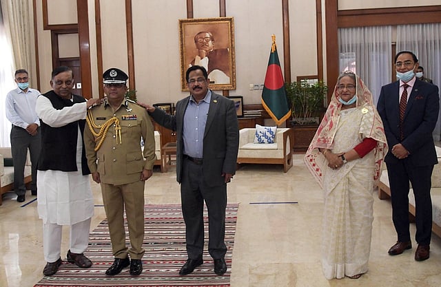 প্রধানমন্ত্রী শেখ হাসিনার উপস্থিতিতে বেনজীর আহমেদকে পুলিশ মহাপরিদর্শকের র‌্যাঙ্ক ব্যাজ পরিয়ে দেন স্বরাষ্ট্রমন্ত্রী আসাদুজ্জামান খান। ছবি: পুলিশ সদর দপ্তর