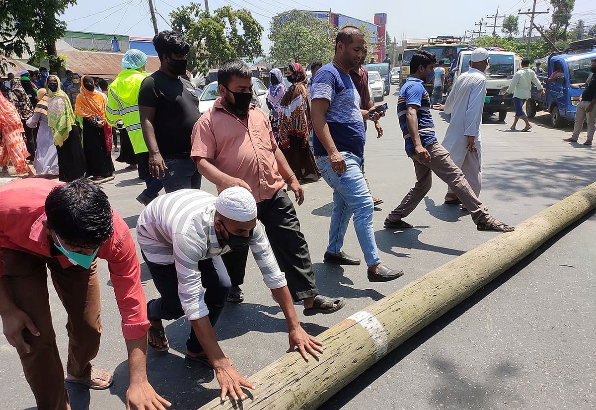 বকেয়া বেতনের দাবিতে ঢাকা-সিলেট মহাসড়কে খাম্বা ফেলে বিক্ষোভ করেন পোশাকশ্রমিকেরা। আজ রোববার বেলা ১১টার দিকে মাধবদীর জেএস লিংক লিমিটেড কারখানার সামনে। ছবি: প্রথম আলো