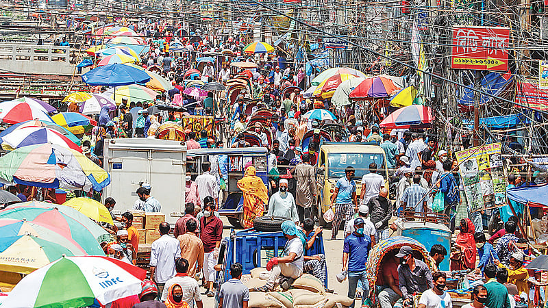 করোনাভাইরাস সংক্রমণ থেকে রক্ষা পেতে দেশজুড়ে সামাজিক দূরত্ব বজায় রাখতে নানা প্রচারণা সত্ত্বেও মানছেন না সাধারণ মানুষ। সড়কজুড়ে নিত্যপণ্যের বাজারে ক্রেতা-বিক্রেতা ও যানবাহনের ভিড়। গতকাল দুপুরে রাজধানীর শনির আখড়ায়।  ছবি: সাজিদ হোসেন