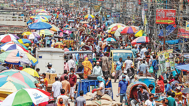 করোনাভাইরাস সংক্রমণ থেকে রক্ষা পেতে দেশজুড়ে সামাজিক দূরত্ব বজায় রাখতে নানা প্রচারণা সত্ত্বেও মানছেন না সাধারণ মানুষ। সড়কজুড়ে নিত্যপণ্যের বাজারে ক্রেতা-বিক্রেতা ও যানবাহনের ভিড়। গতকাল দুপুরে রাজধানীর শনির আখড়ায়।  ছবি: সাজিদ হোসেন