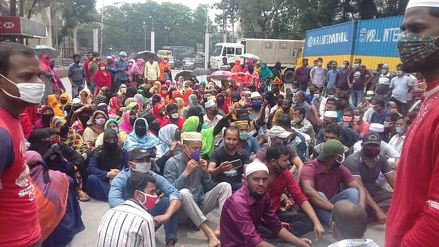 বকেয়া বেতনের দাবিতে এ ওয়ান কারখানার শ্রমিকেরা আজ বুধবার সকালে ঢাকা রপ্তানি প্রক্রিয়াকরণ এলাকার মহাব্যবস্থাপকের কার্যালয়ের সামনে সড়ক অবরোধ করেন। ছবি: প্রথম আলো