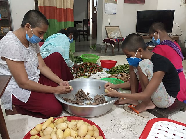 অভুক্ত মানুষের মধ্যে বিতরণের জন্য খাবার তৈরি করছেন লিজা (বামে) ও অন্যরা। ছবি: প্রথম আলো