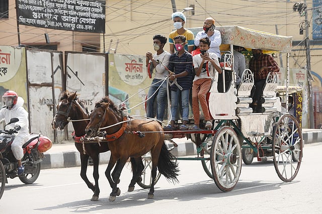 করোনা থেকে রক্ষা পেতে সামাজিক দূরত্ব মানছে না কেউ। ঘোড়ার গাড়িতে গাদাগাদি করে এক জায়গা থেকে অন্য জায়গায় যাচ্ছে যাত্রীরা। টয়েনবি সার্কুলার রোড, ঢাকা, ৫ মে। ছবি: আশরাফুল আলম