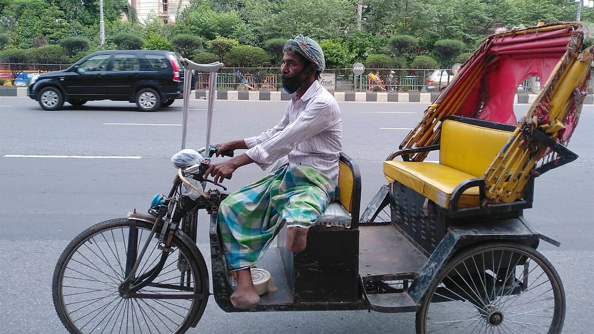 করোনা মহামারির মধ্যেও জীবিকার জন্য রিকশা নিয়ে বের হতে হয় দুই পা হারানো অনিলকে। ছবি: সেলিম জাহিদ