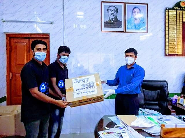 যশোরের সিভিল সার্জন শেখ আবু শাহীনের হাতে ফেসশিল্ড ভর্তি কার্টন তুলে দিচ্ছেন ‌‌‘‌পাশে আছি আমরা’ সংগঠনের কয়েকজন সদস্য। ছবি: প্রথম আলো