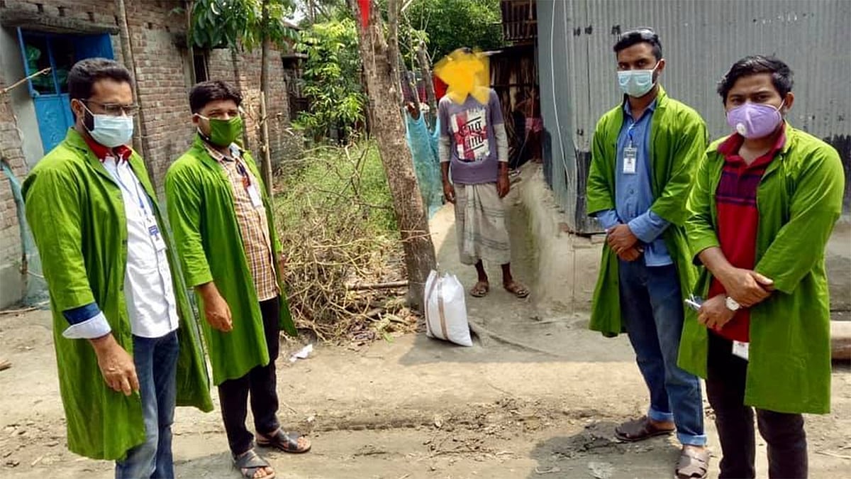 নাটোরের গুরুদাসপুরে হোম কোয়ারেন্টিনে থাকা এক ব্যক্তির বাড়িতে খাদ্যসামগ্রী নিয়ে হাজির স্বেচ্ছাসেবকেরা। ছবি: প্রথম আলো