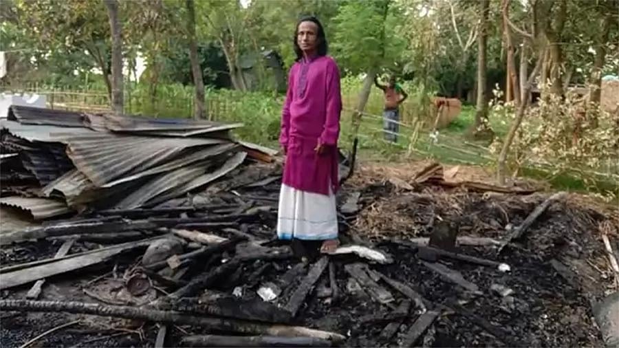 পুড়ে যাওয়া ঘরের ধ্বংসস্তূপের ওপর বাউল রণেশ ঠাকুর। ছবি: ফেসবুক থেকে নেওয়া
