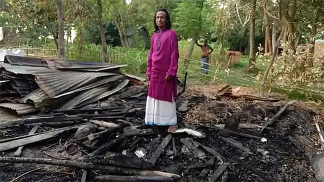 পুড়ে যাওয়া ঘরের ধ্বংসস্তূপের ওপর বাউল রণেশ ঠাকুর। ছবি: ফেসবুক থেকে নেওয়া