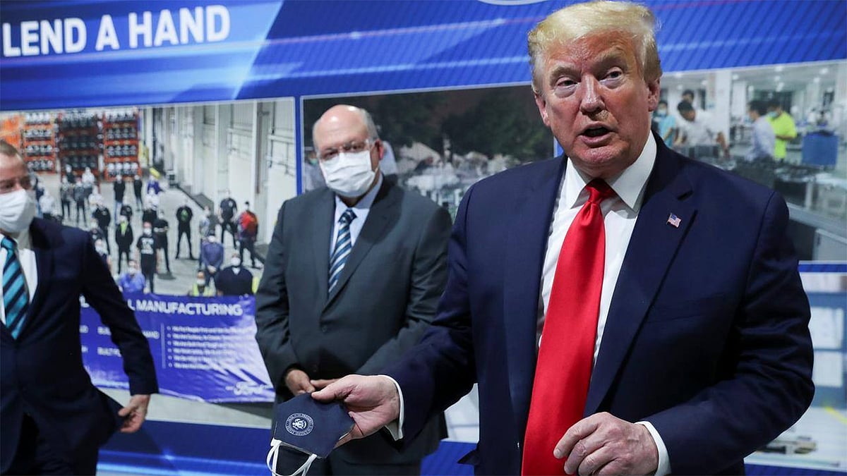 হাতের মাস্ক সাংবাদিকদের দেখাচ্ছেন মার্কিন প্রেসিডেন্ট ডোনাল্ড ট্রাম্প। ছবি: রয়টার্স