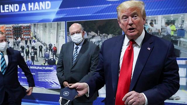 হাতের মাস্ক সাংবাদিকদের দেখাচ্ছেন মার্কিন প্রেসিডেন্ট ডোনাল্ড ট্রাম্প। ছবি: রয়টার্স