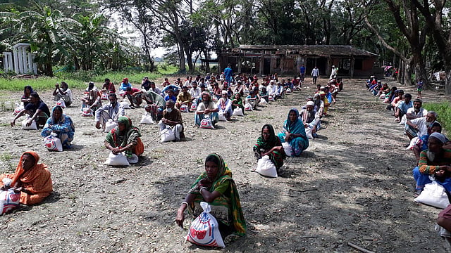করোনাভাইরাসের সংক্রমণের আশঙ্কায় সামাজিক দূরত্ব বজায় রেখে বিতরণ করা হয় ত্রাণ। ছবি: প্রথম আলো