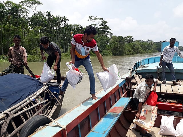 ঘূর্ণিঝড় আম্পানে ক্ষতিগ্রস্ত চরের মানুষের জন্য খাদ্যসামগ্রী নিয়ে যাচ্ছেন বন্ধুসভার সদস্যরা। বড়মাছুয়া গ্রাম, মঠবাড়িয়া, পিরোজপুর।