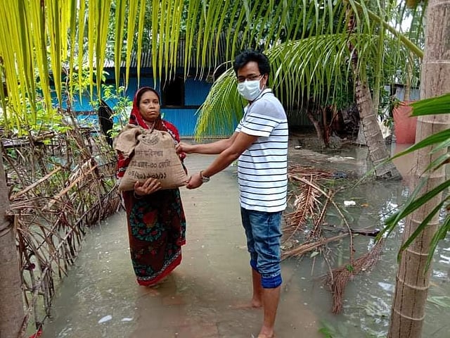 আম্পানে পানিবন্দী মানুষের বাড়িতে খাদ্যসামগ্রী দিচ্ছেন পিরোজপুর সদর উপজেলার সহকারী কমিশনার (ভূমি) রামানন্দ পাল। নরখালী গ্রাম, পিরোজপুর সদর।