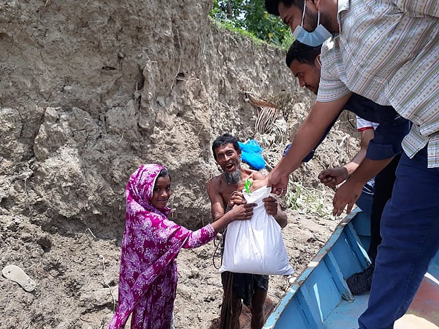 ঘূর্ণিঝড় আম্পানে ক্ষতিগ্রস্ত বাবা ও মেয়ের হাতে খাদ্যসামগ্রী তুলে দিচ্ছেন পিরোজপুর বন্ধুসভার বন্ধুরা। চর ভোলামারা, মঠবাড়িয়া, পিরোজপুর।