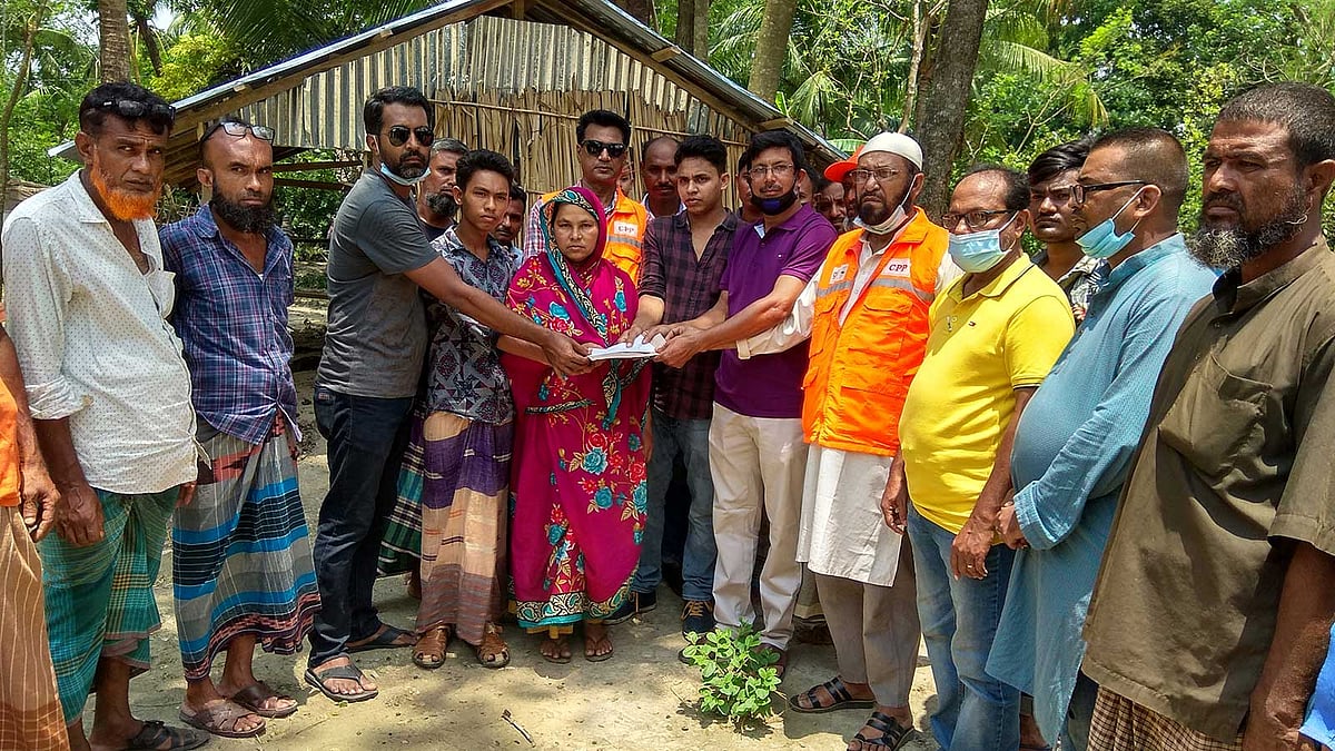 ঘূর্ণিঝড় প্রস্তুতি কর্মসূচির দলনেতা শাহ আলম মীরের পরিবারের সদস্যদের হাতে অর্থসহায়তা তুলে দেওয়া হচ্ছে। ছবি: নেছারউদ্দিন আহমেদ